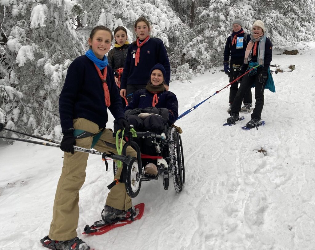 Les guides-aînées du Feu Notre-Dame des Lumières gravissant le puy de Lassolas avec leur cheftaine en fauteuil roulant.