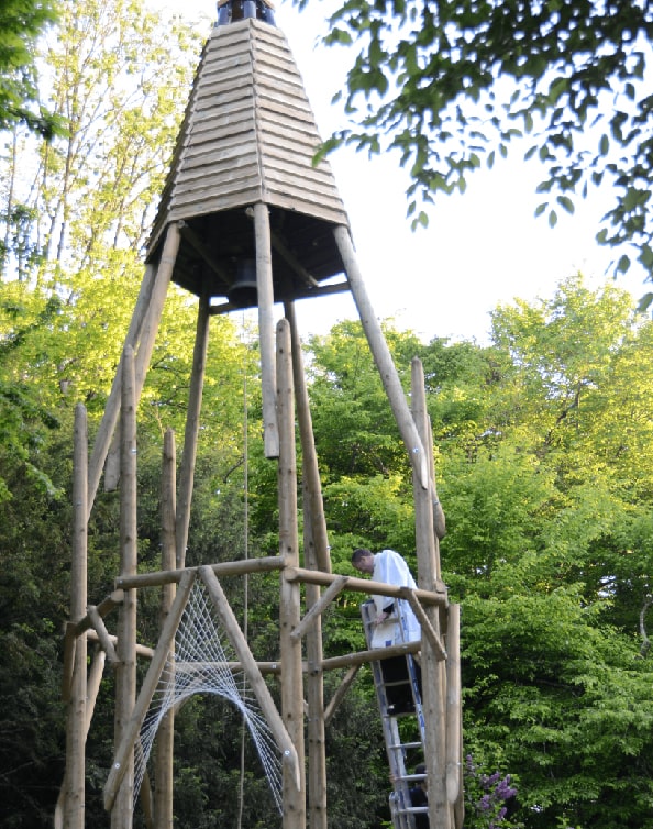 L'abbé Cyril Gordien, monté sur une échelle, bénie la cloche Sainte-Thérèse à Château-Landon